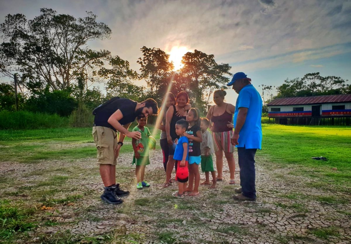 Guest in the village with children sharing the photo on his camera.